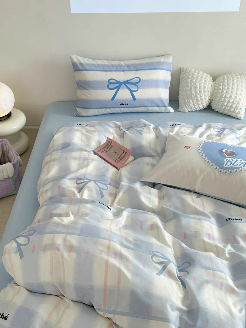 Bedding set with decorative pillows and a tag on a bed in a room.