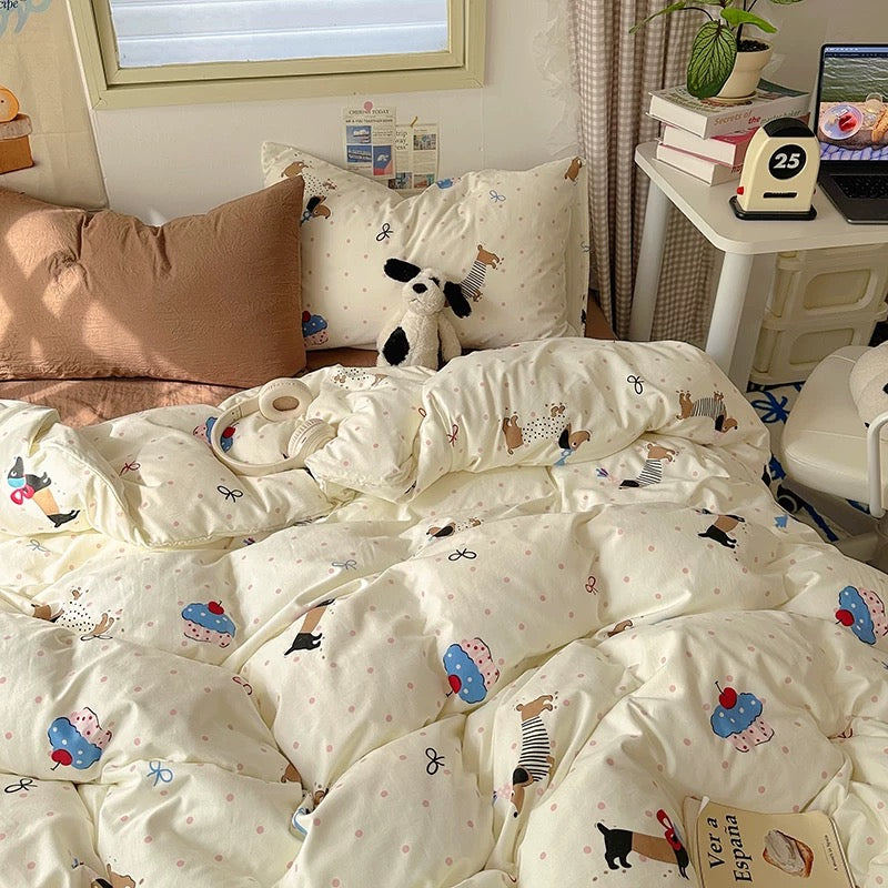 Bed with cartoon-themed bedding in a room with a desk and books.