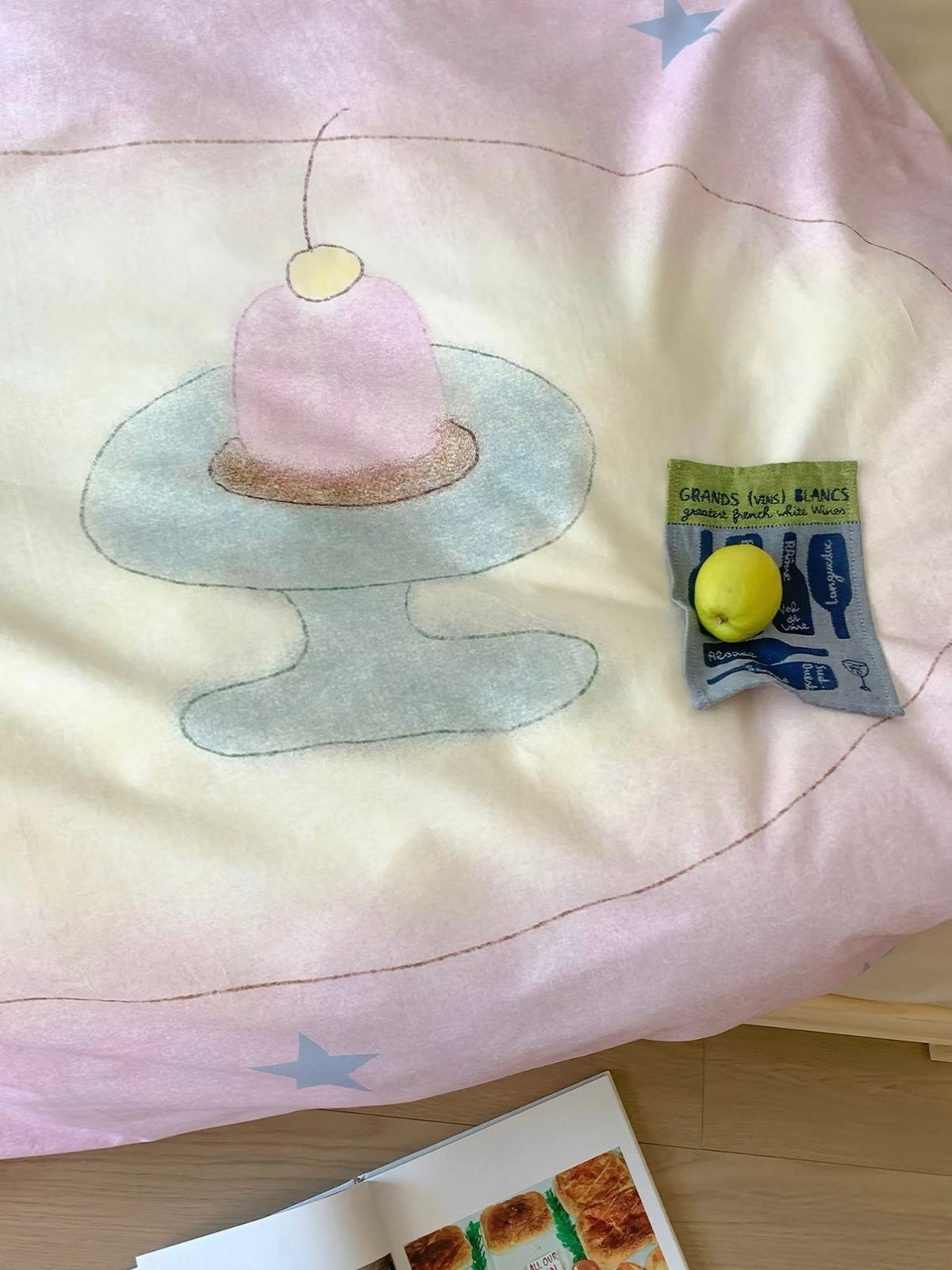 A pink candle on a pale green stand illustrated across the pastel duvet cover.