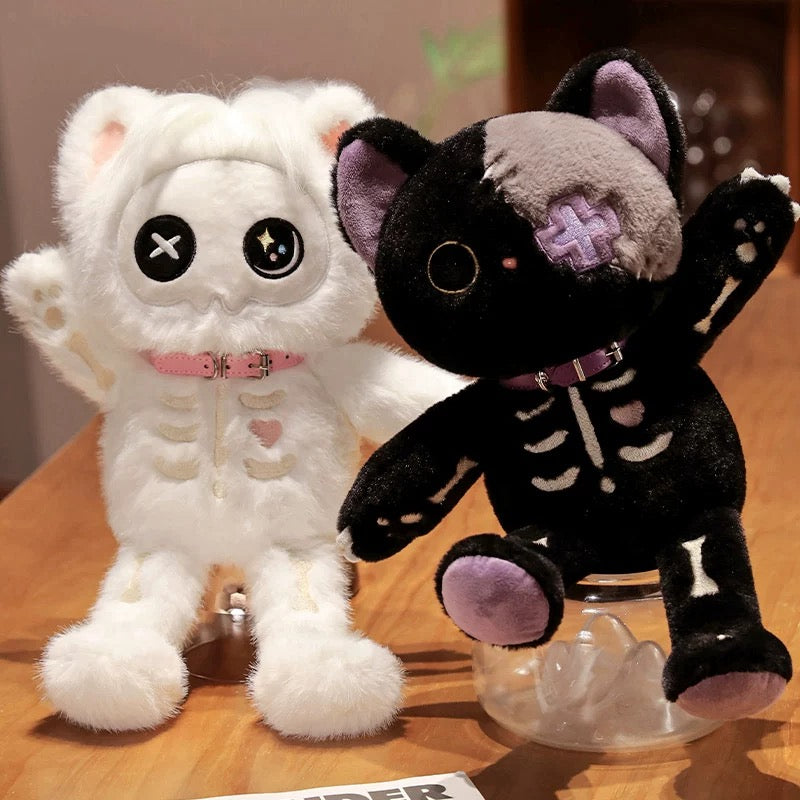 Two plush toys, one white and one black, with skeleton designs on a wooden surface.