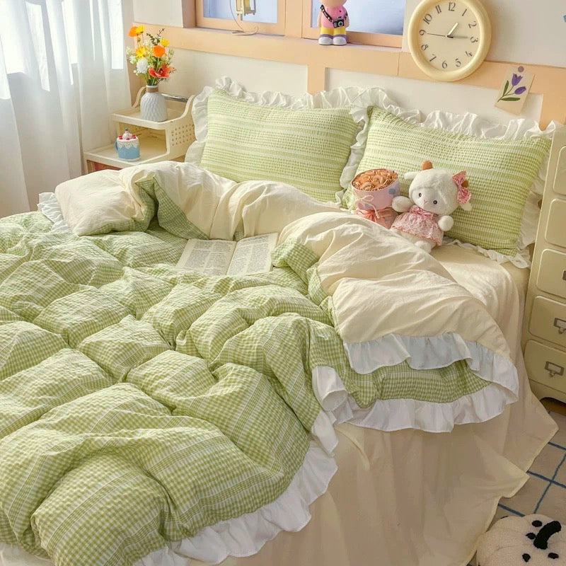 Bed with green and white checkered bedding, pillows, and stuffed toys in a bedroom setting.