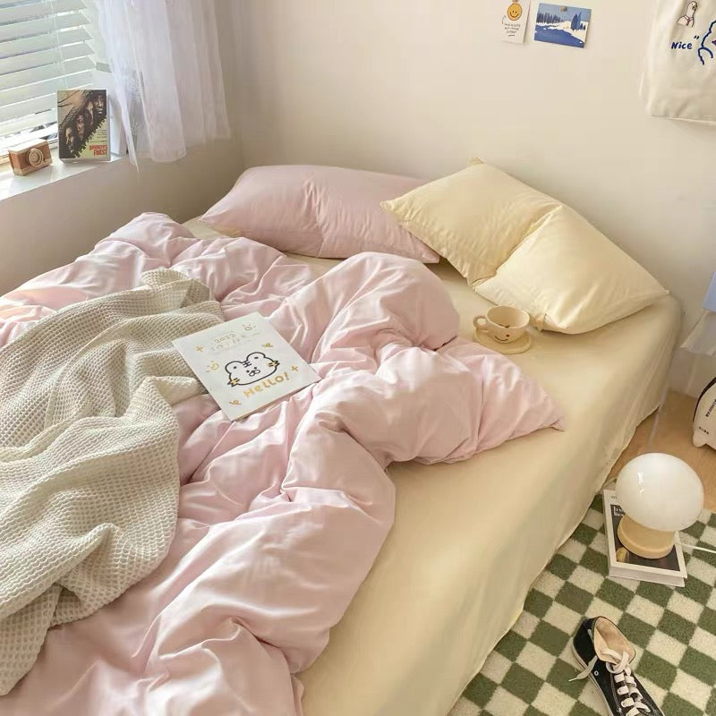Pastel pink and cream bedding set with soft duvet cover and pillowcases styled in a cozy bedroom.