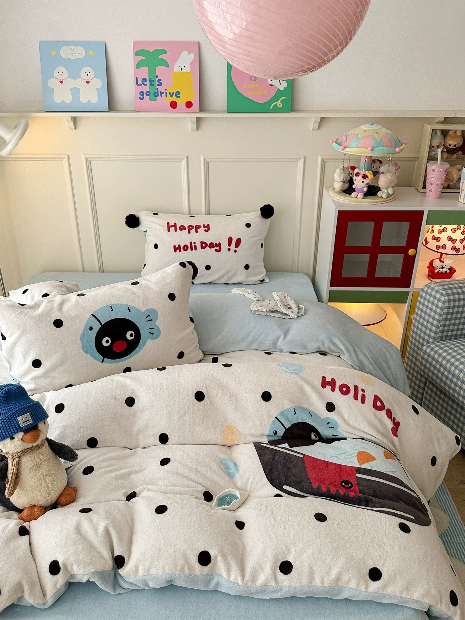Penguin milk fleece bedding set styled on bed with pom pom pillows in cozy winter room