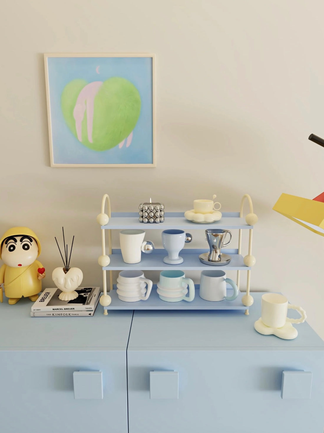 Blue perfume display shelf with cream arches and ball details holds cups and saucers across open tiers.