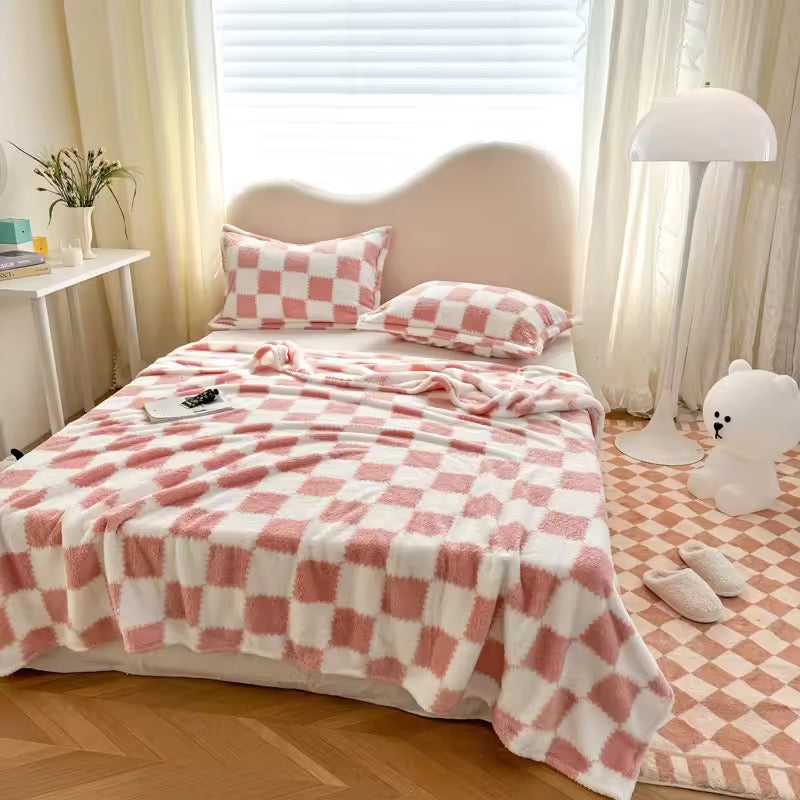 Bedroom with pink and white checkered bedding, pillows, and a lamp.