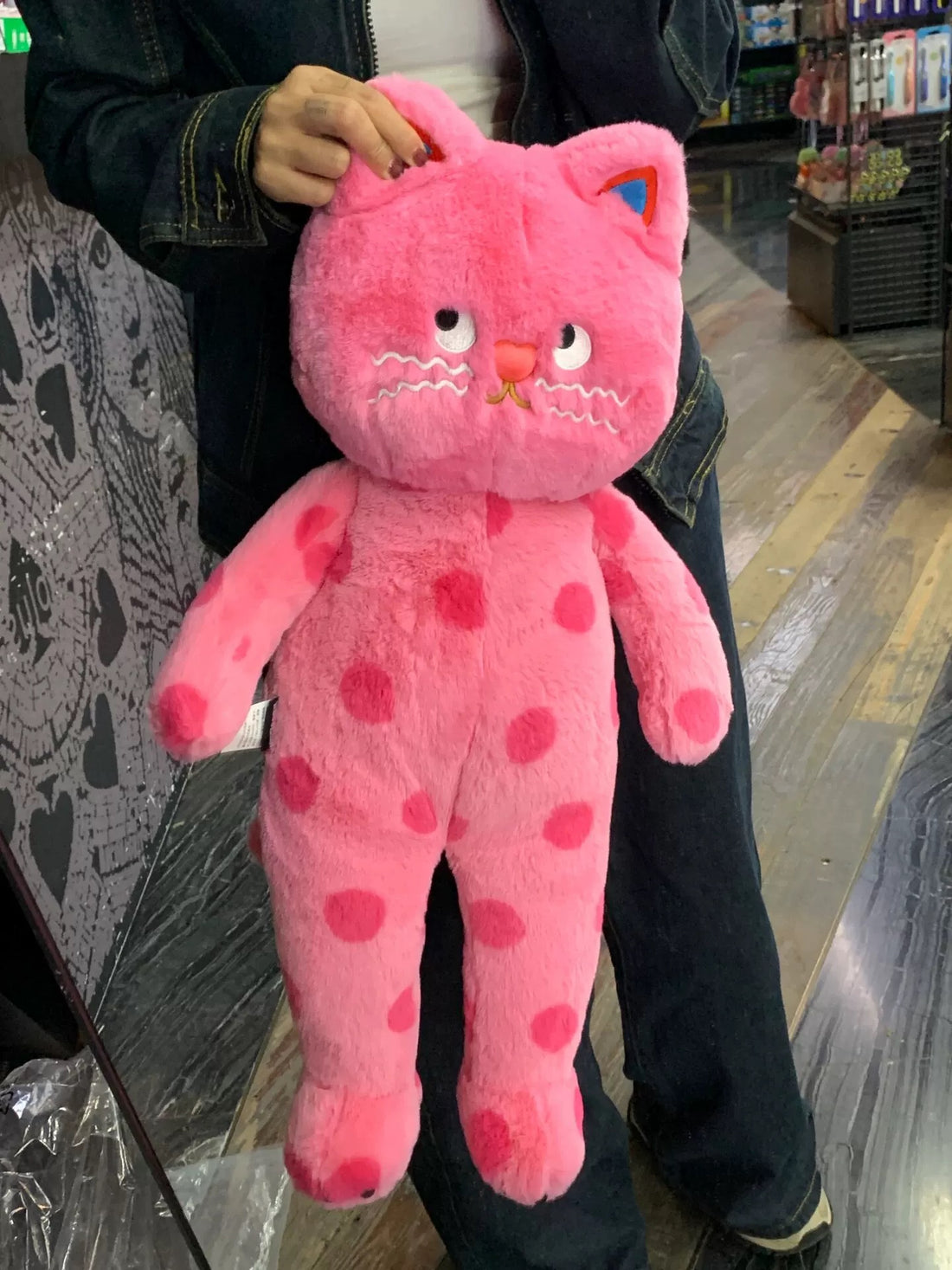 Soft pink cat plush toy with polka dots for cozy room decor