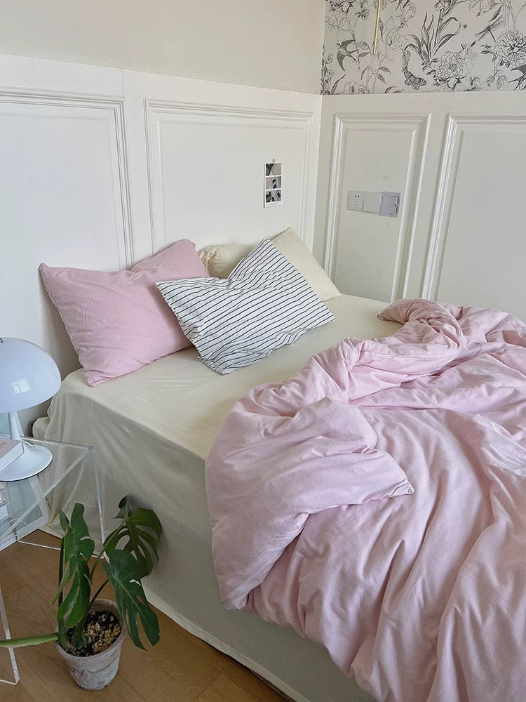 Soft pink duvet cover with a cream-yellow pillowcase in a bright bedroom