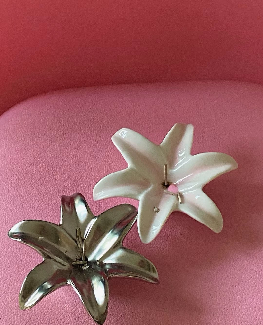 Two decorative plant-shaped candles on a pink chair.