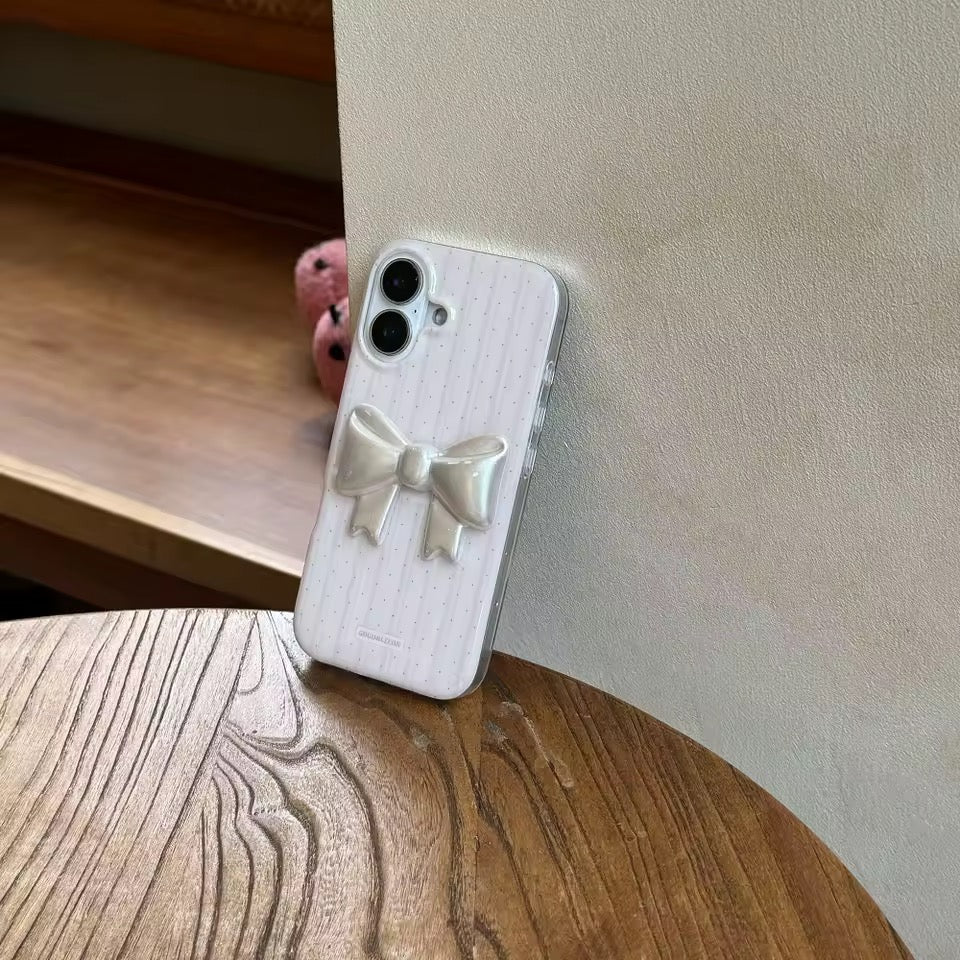 Phone case with a bow design on a wooden surface