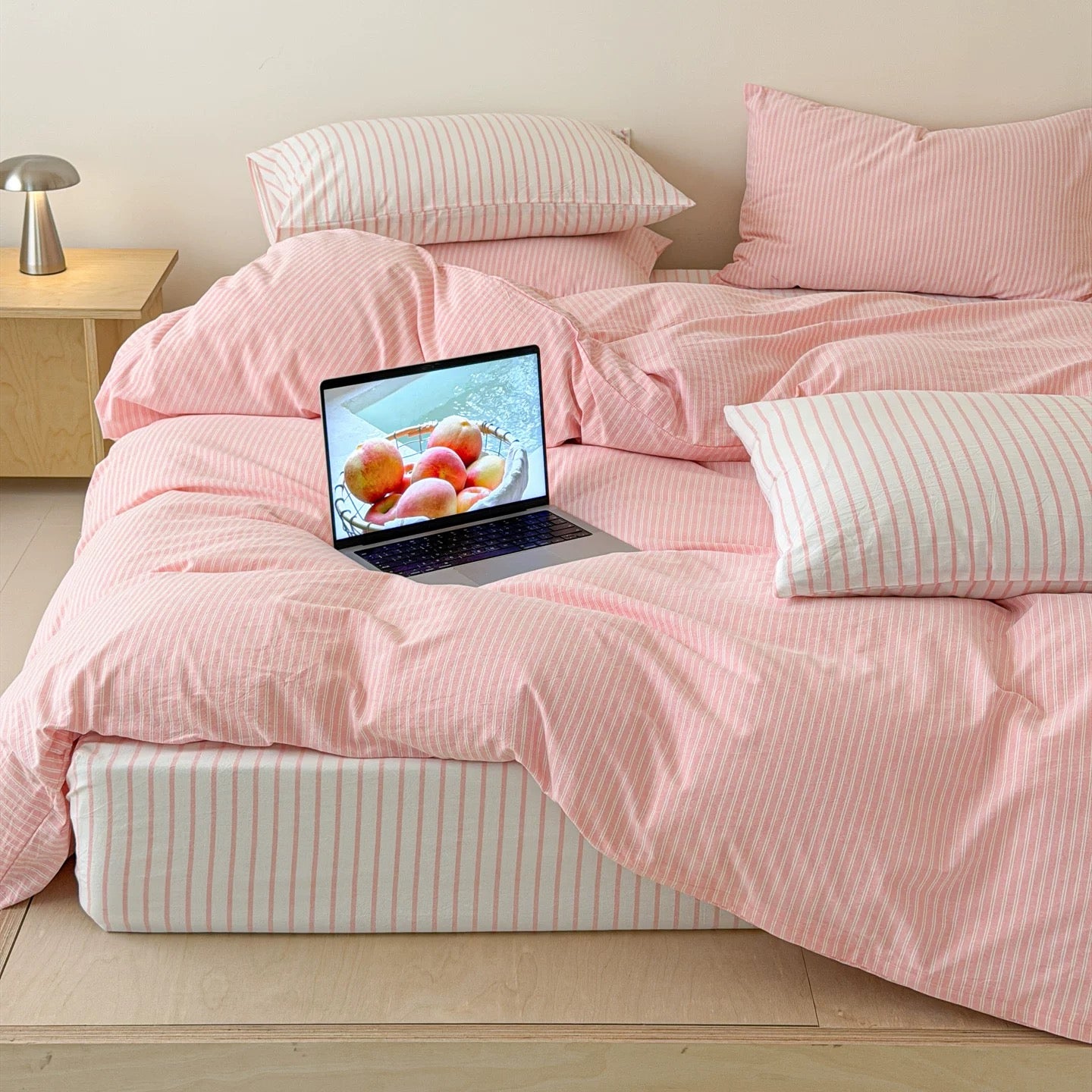 Breathable cotton pink striped bedding creating cozy Scandinavian inspired sleep space with soft layered textures today.