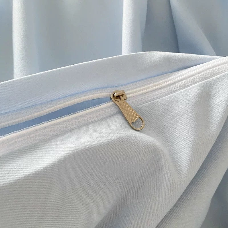 Pastel blue duvet cover with cream flat sheet aesthetic bedding for dorm room.