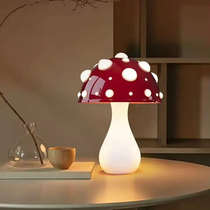 Mushroom-shaped table lamp with a red and white polka dot design on a wooden surface.