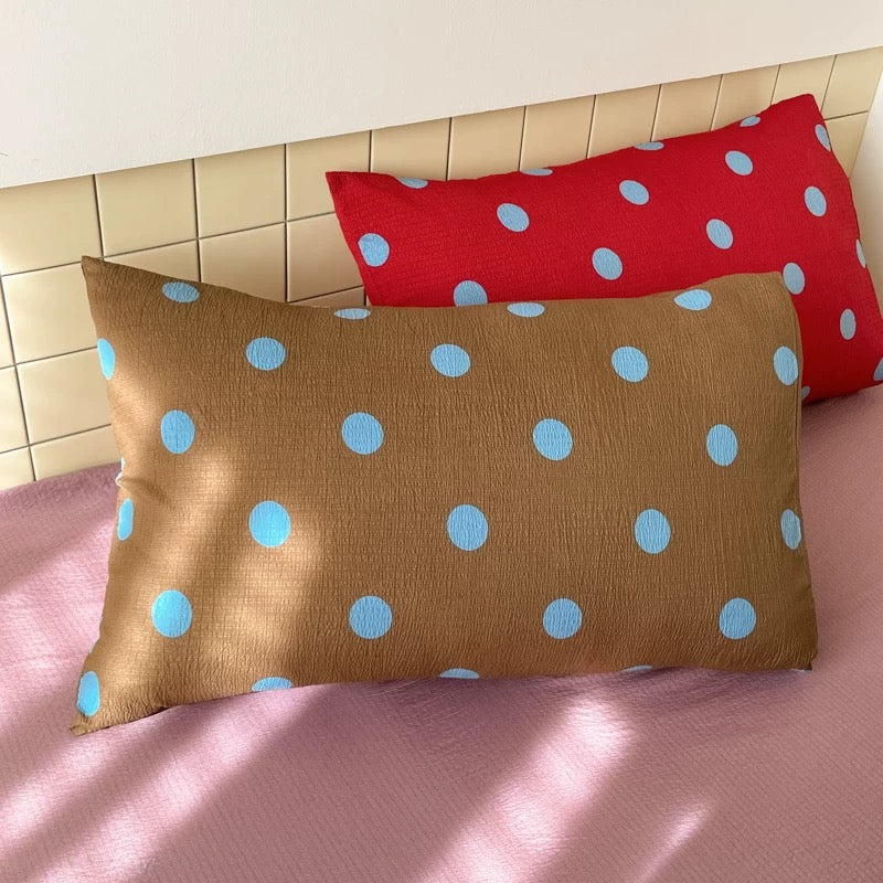 Charcoal gray bedding with pink polka dots creating bold preppy bedroom visual statement