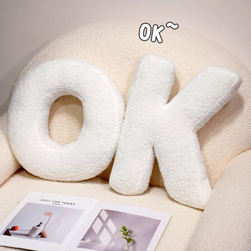 White letter-shaped cushions spelling 'OK' on a light background