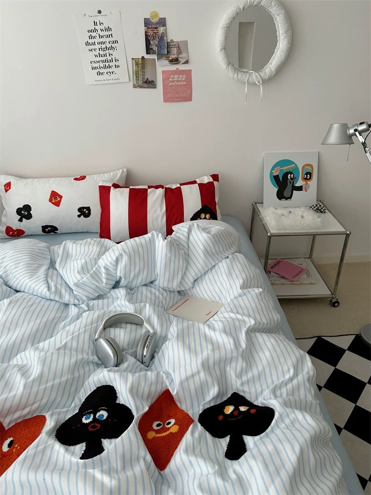 Bed with cartoon-themed bedding in a room with checkered floor and wall decorations.