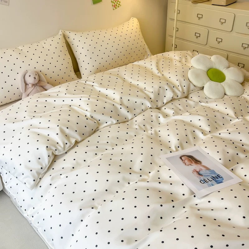Polka dot satin duvet cover on cozy summer bed with matching pillowcases.