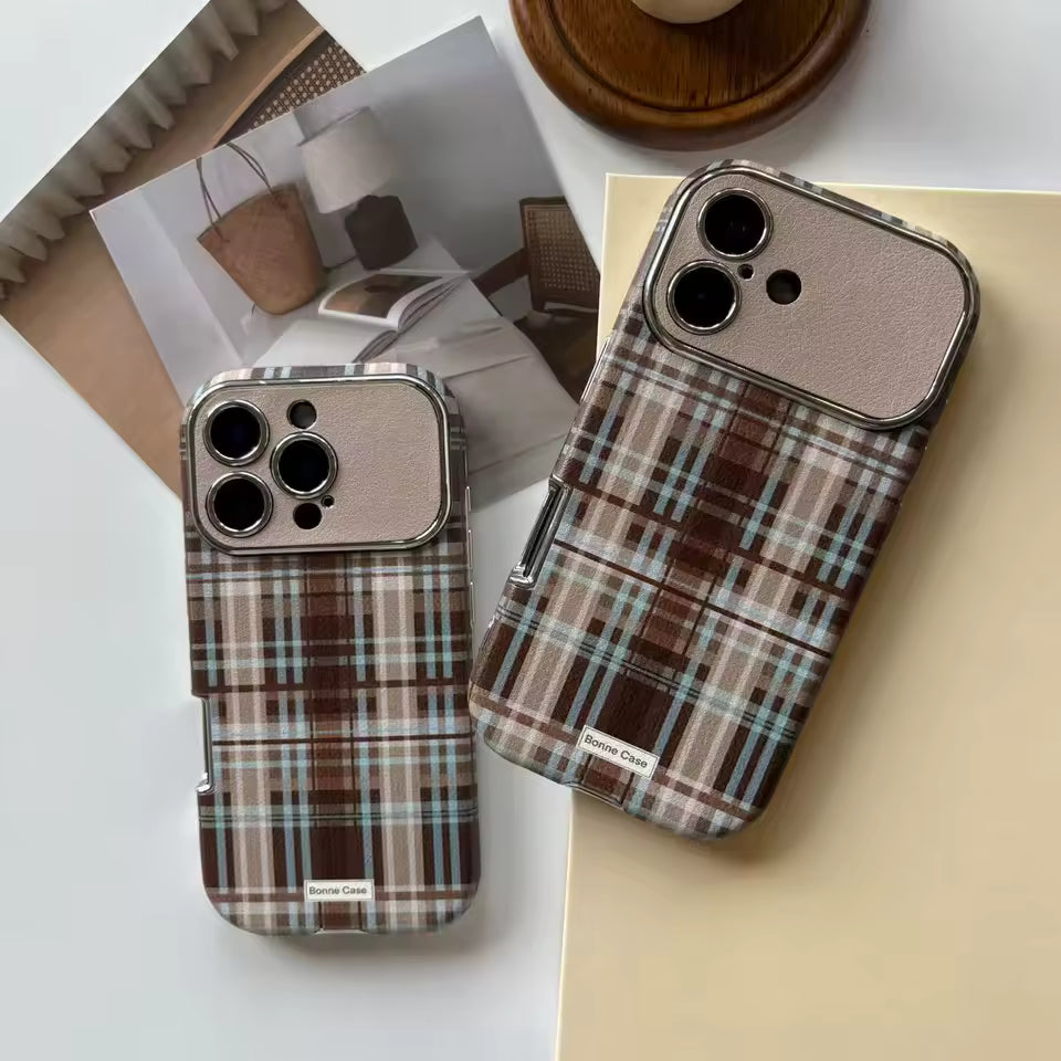 Two plaid phone cases on a white surface with a magazine in the background.