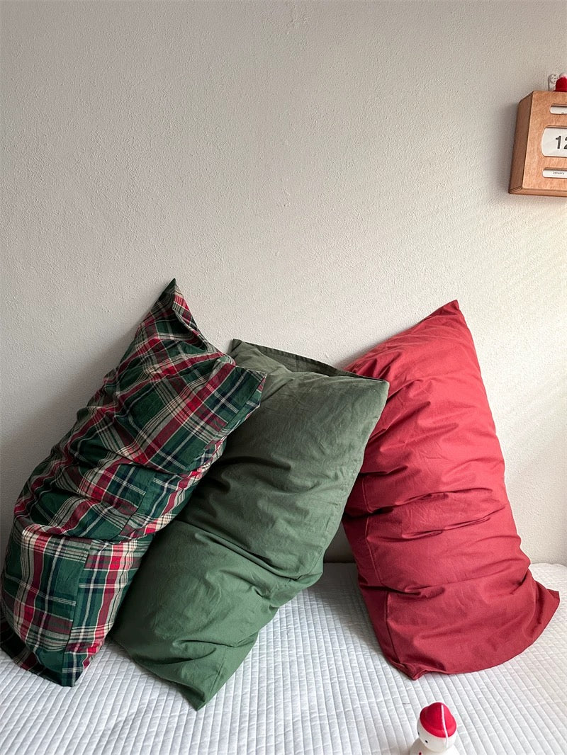 Preppy pillowcase designs combine red and green tartan with solid green and red, shown from the side.