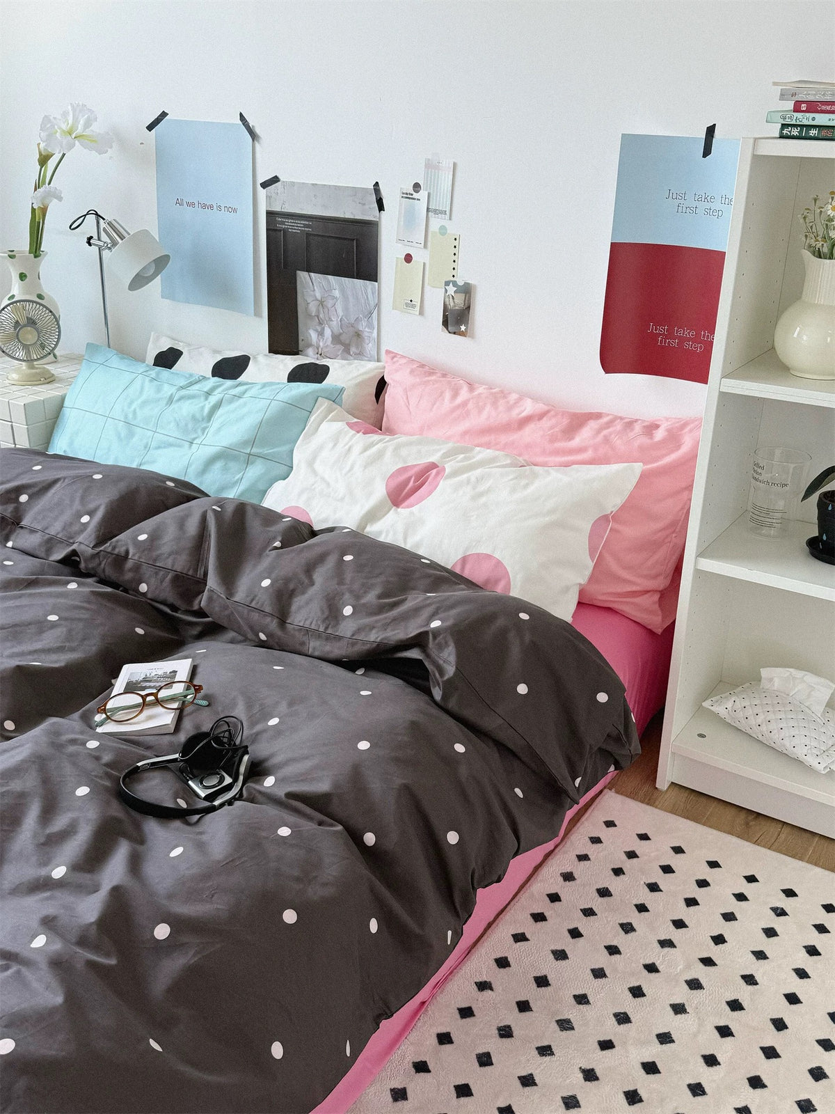 A full side view of preppy pink bedding shows the small dotted cover and a mixed group of checked and dotted pillows.