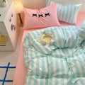 Preppy room decor ideas with pastel-striped bedding and aesthetic pillows