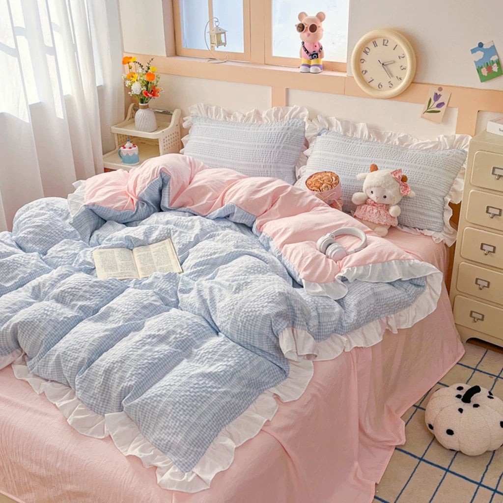 Bedroom with pink and blue bedding, pillows, and stuffed toys.