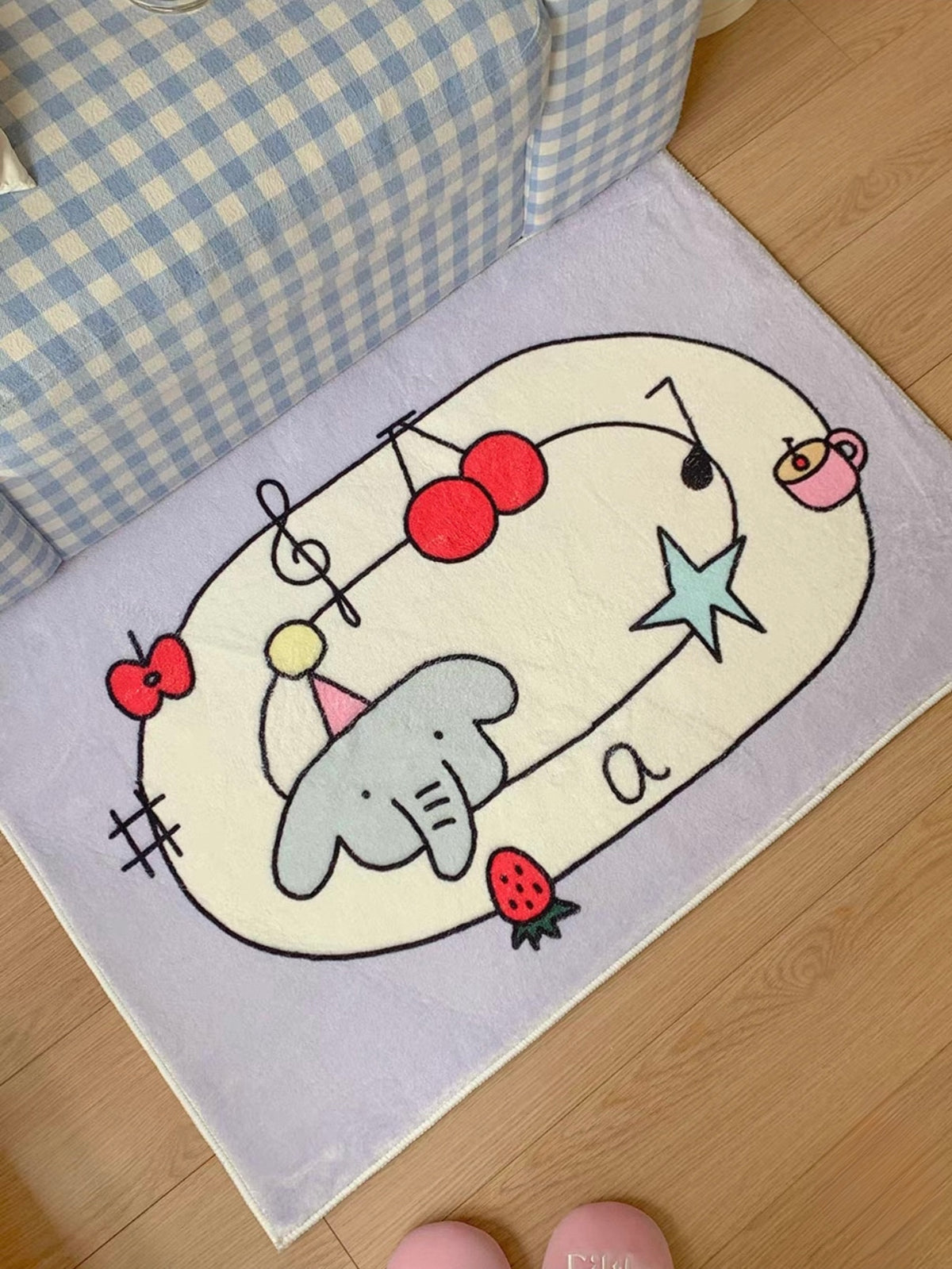 A purple cherry rug is viewed at an angle, with an elephant, musical notes and a blue star inside the oval.