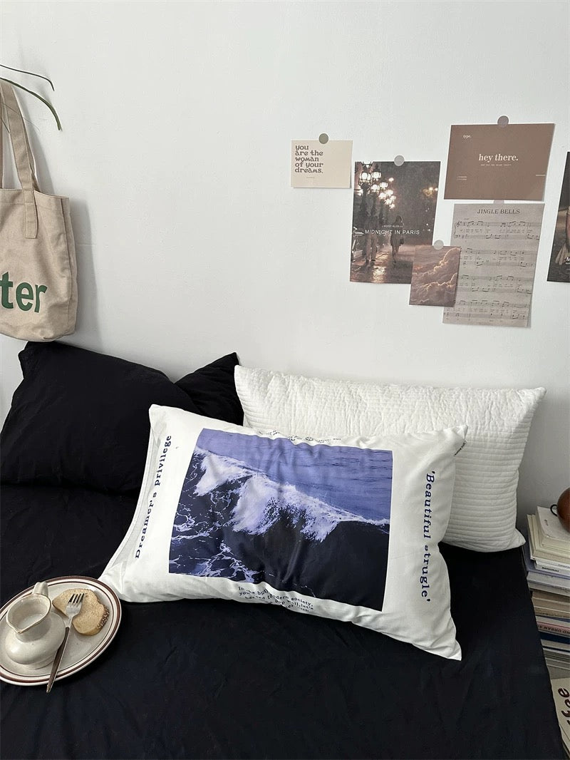 Decorative pillow with a blue design on a bed in a room setting.