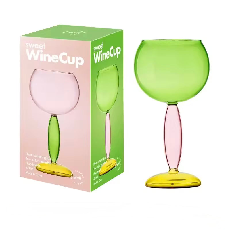 Green and pink wine glass with packaging on a white background