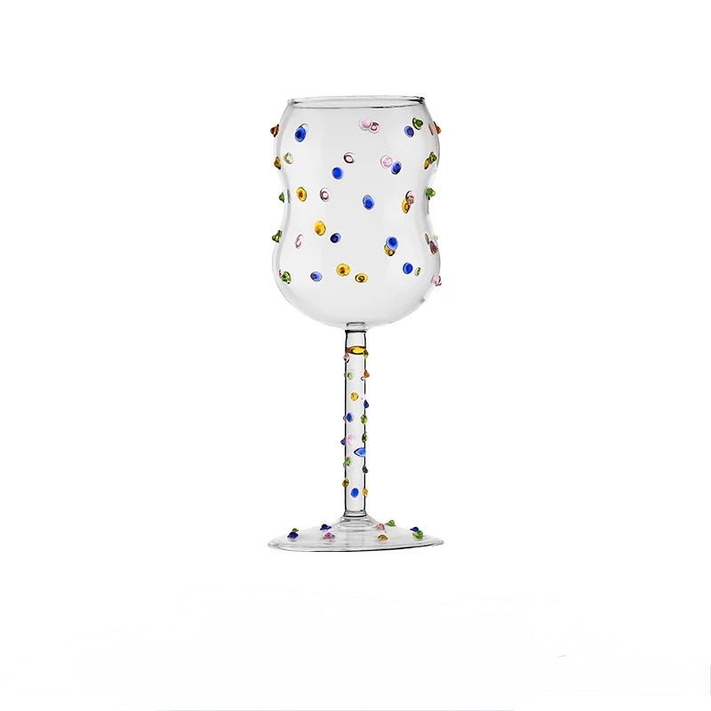 Decorative wine glass with colorful beads on a white background