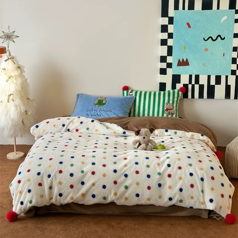 Children's bedroom with polka dot bedding, teddy bear, and colorful wall art.