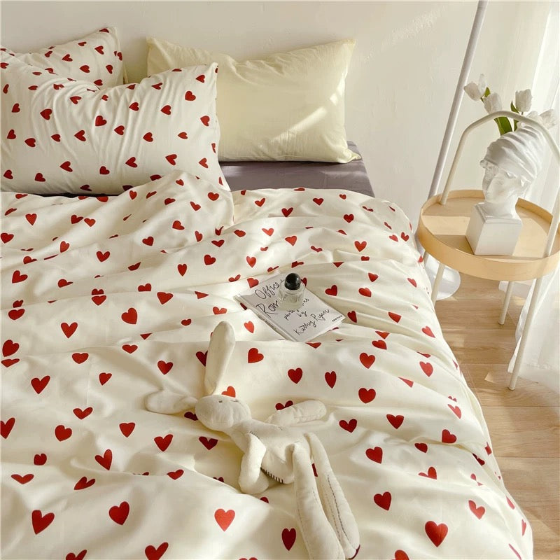 Heart duvet cover styled on a bed with red hearts over a white cotton base