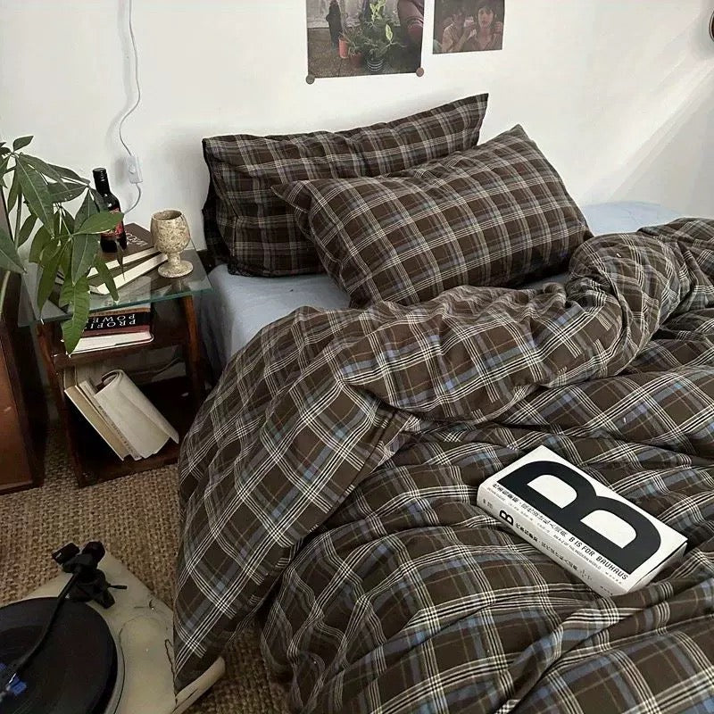 Bed with plaid bedding and a book titled 'B' on a nightstand.
