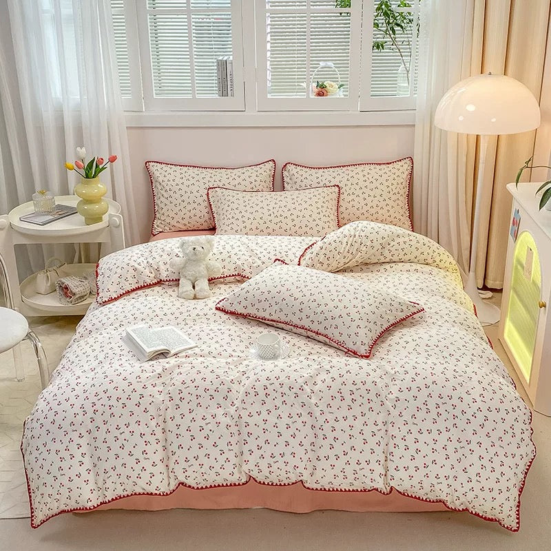 Pink duvet cover with red cherry print on a cozy bed