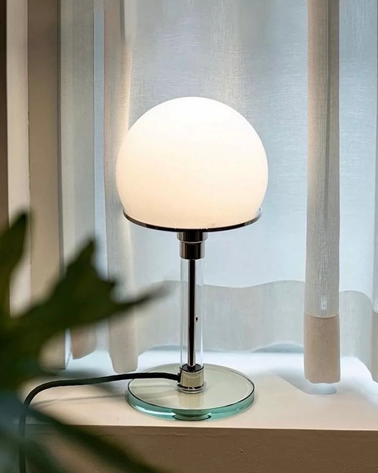 Retro chrome mushroom lamp with soft warm light styled near grapes, book, and neutral decor.