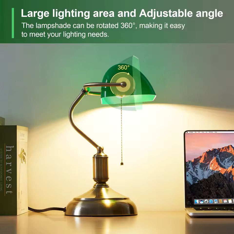 Vintage-style desk lamp with adjustable shade on a desk next to a laptop and book.