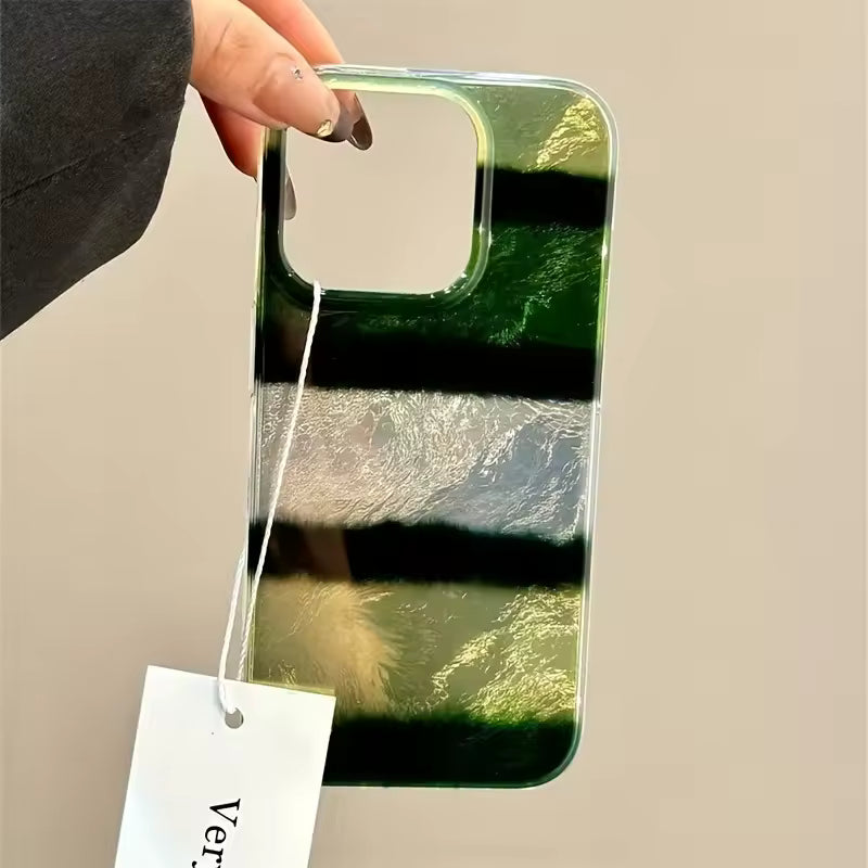 Phone case with green and black gradient held by a hand on a beige background