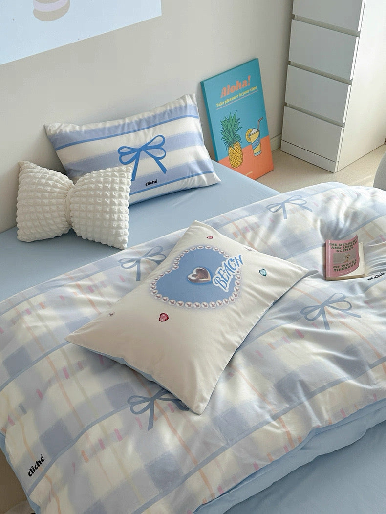 Children's bedroom with bedspread, pillows, and books on a bed.