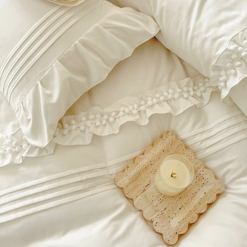 White lace doily with a candle on a white bedspread