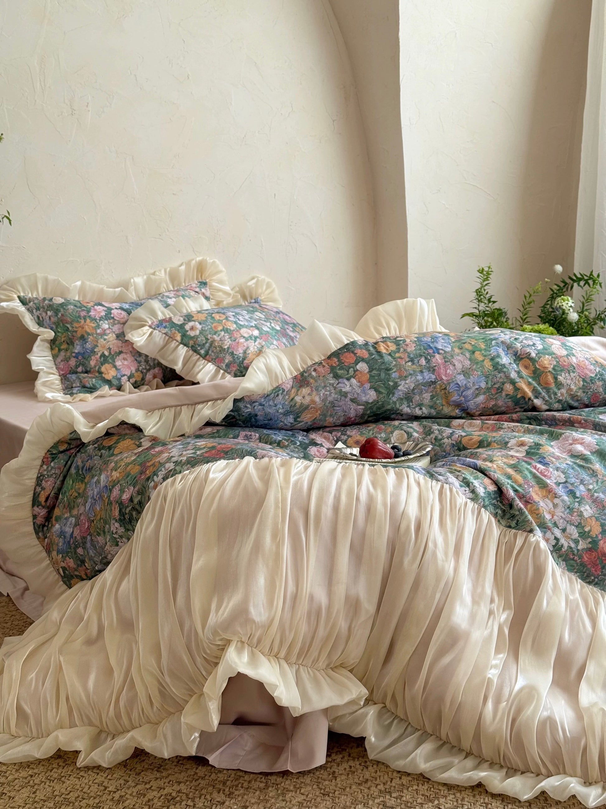 Floral bedding set with ruffled edges on a bed in a softly lit room.