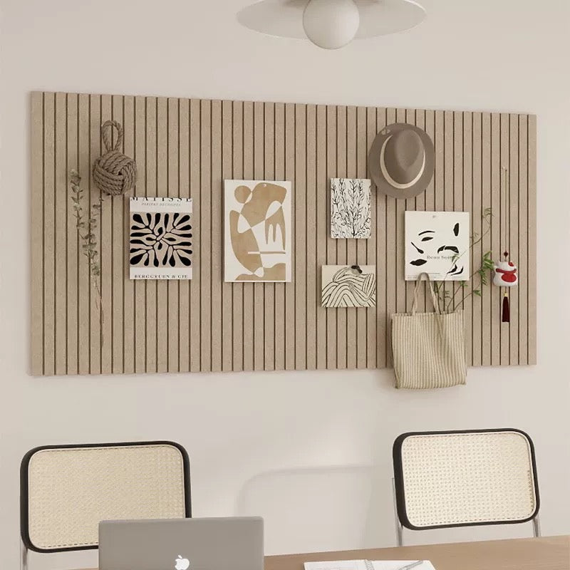 Wall with decorative items including a hat, plants, and abstract art in a room with chairs and a table.