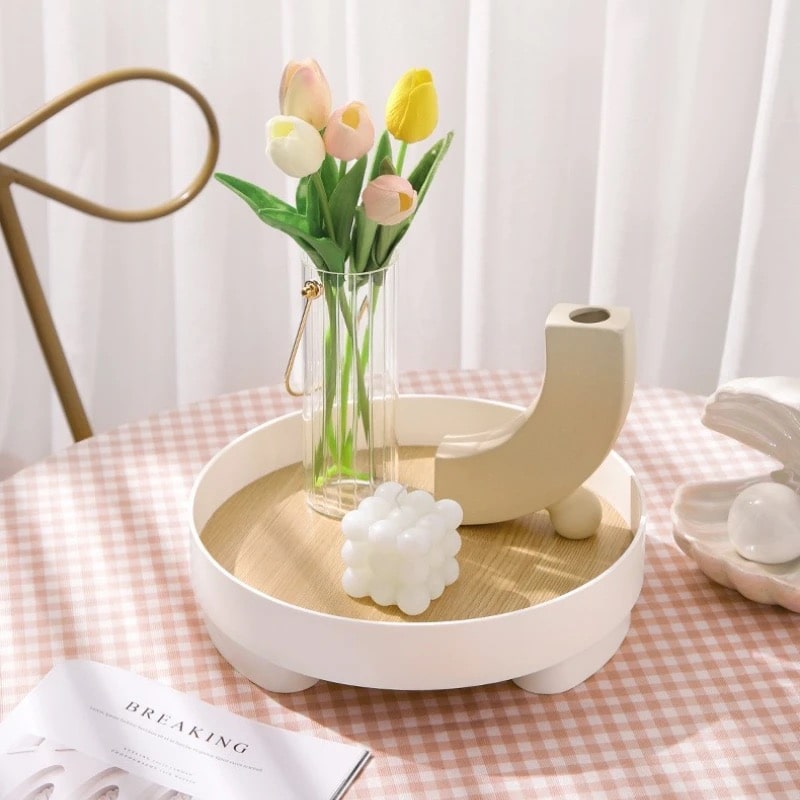 Round Danish platform tray on coffee table with decorative items.