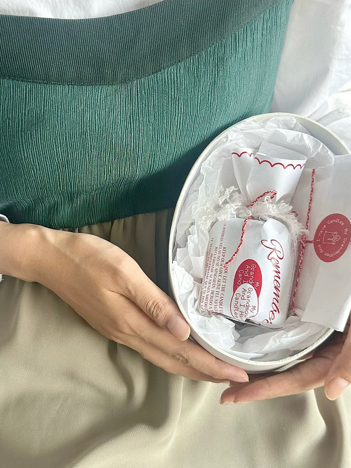 Scented candle gift box held open with wrapped candle inside