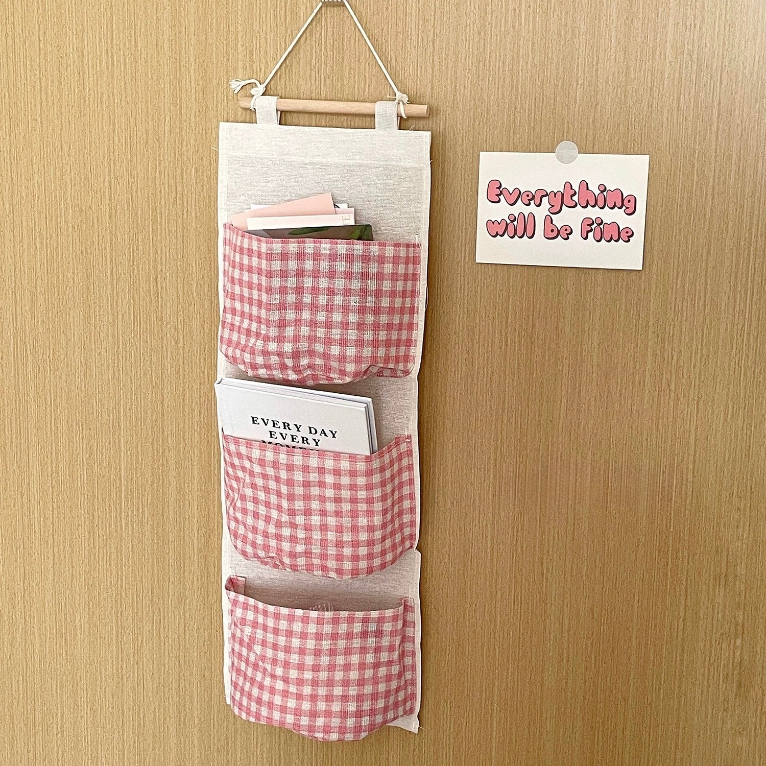 Hanging organizer with red and white checkered pockets on a wooden wall.