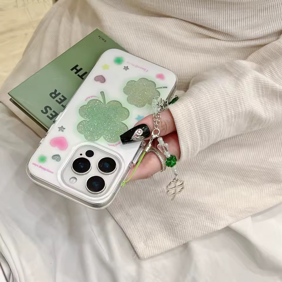 Phone case with clover design held by a person wearing a beige sweater.