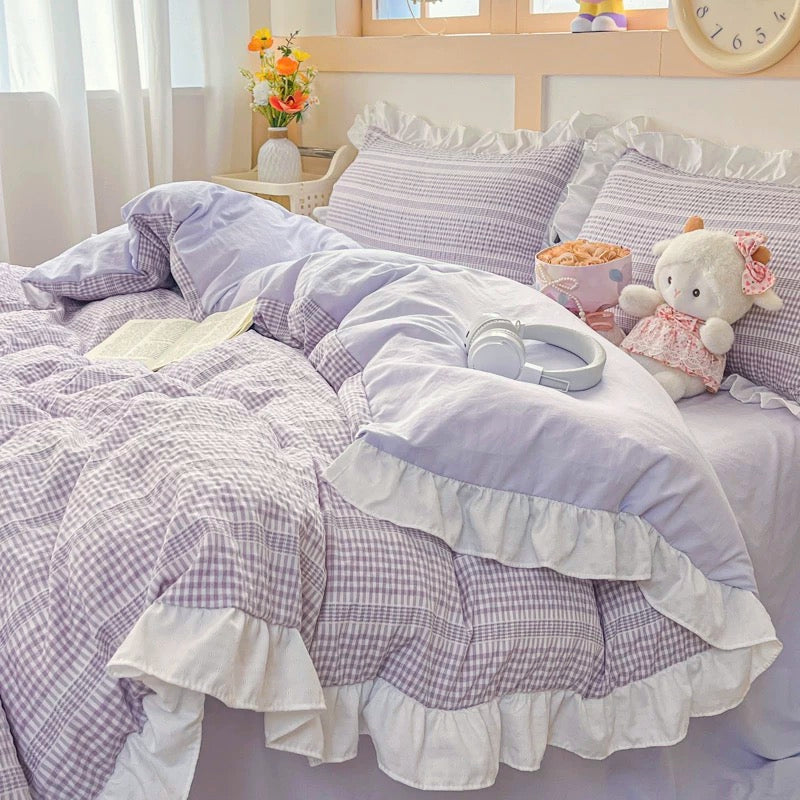 Bed with purple and white checkered bedding in a bright room.