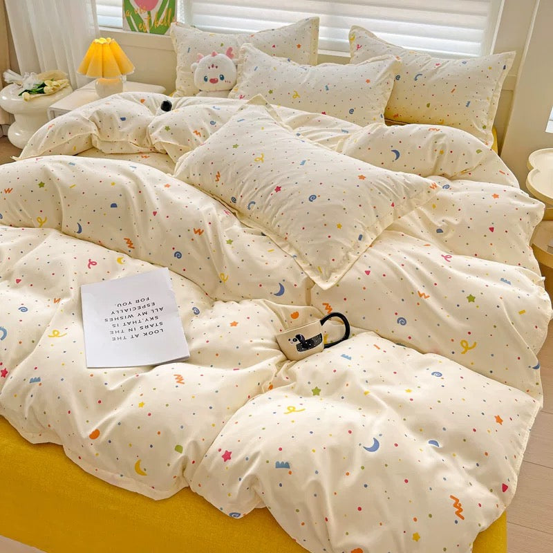 Close-up of butter-cream comforter fabric featuring rainbow dots and tiny stars