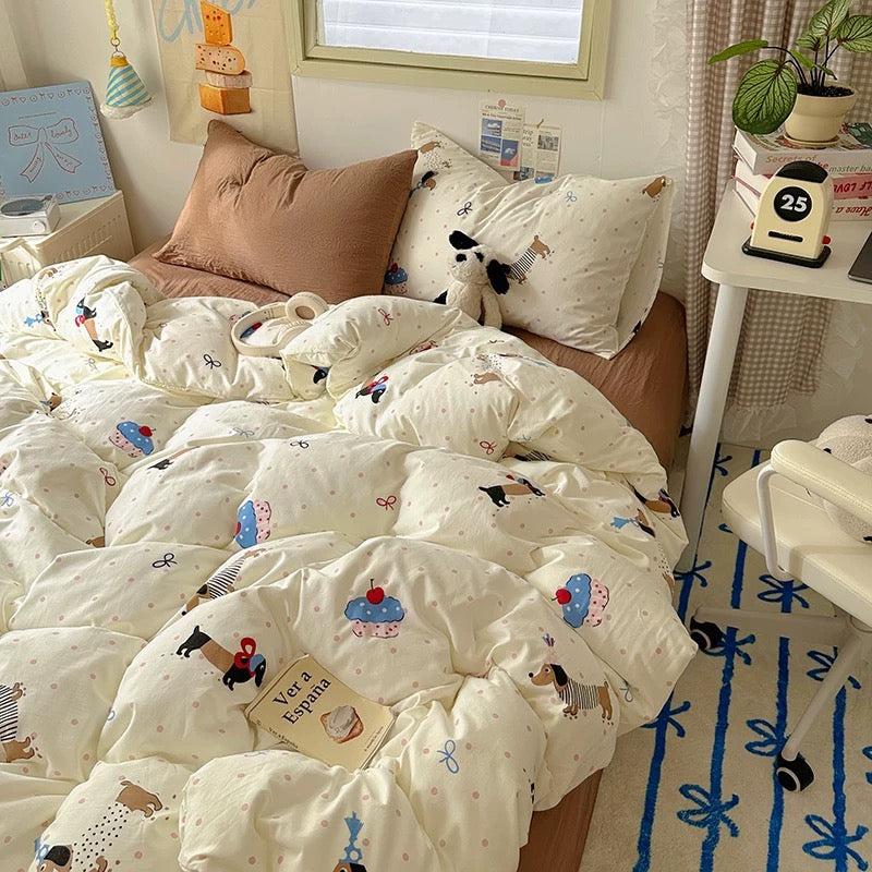 Children's bedroom with a bed covered in patterned bedding, pillows, and a small table with decor items.