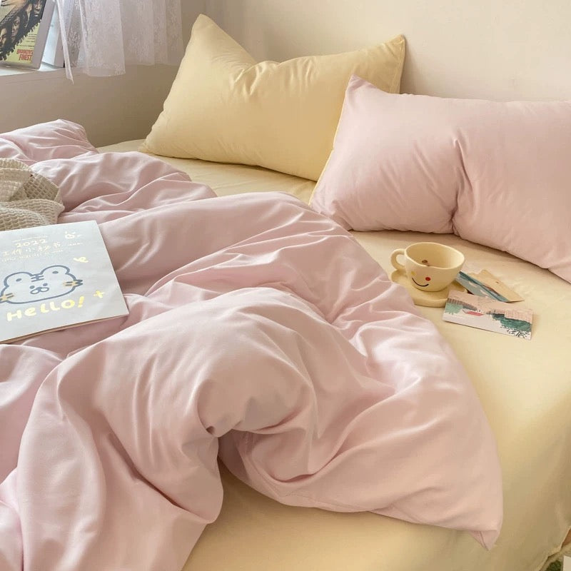 Cozy student dorm room decor with pastel bedding set in soft pink and neutral cream colors.