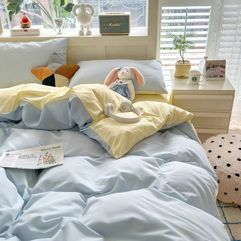 Bed with light blue and yellow bedding in a bright bedroom