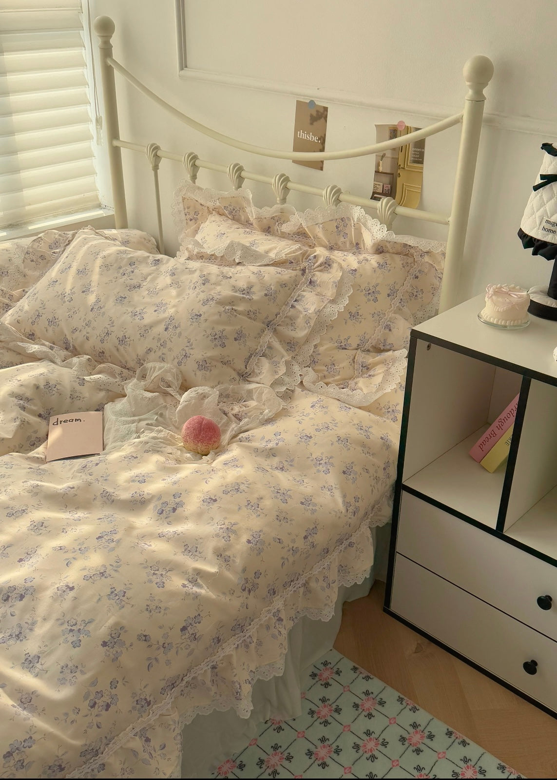 Bed with floral bedding in a room with a small nightstand.